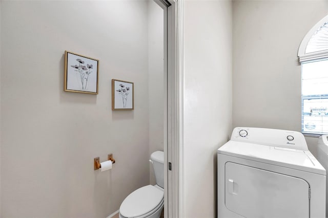 bathroom with toilet and separate washer and dryer