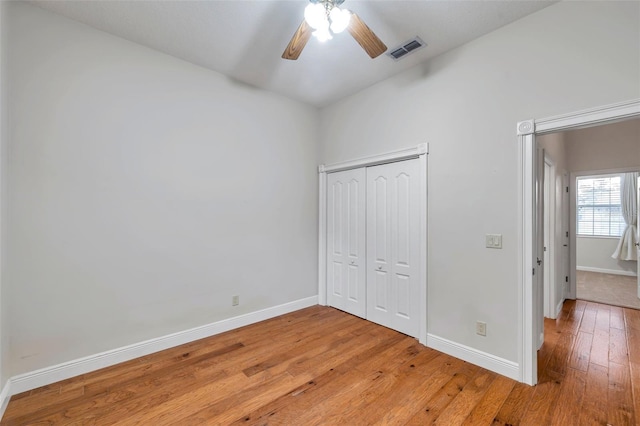 unfurnished bedroom featuring ceiling fan, a closet, and light hardwood / wood-style flooring