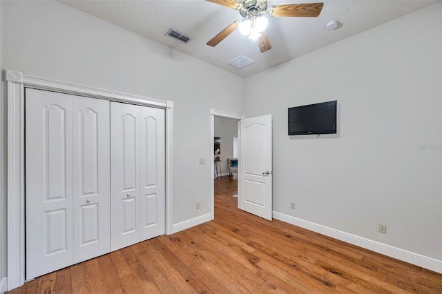 unfurnished bedroom with ceiling fan, light hardwood / wood-style floors, and a closet