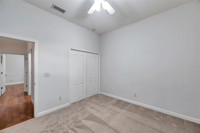 unfurnished bedroom with ceiling fan, a closet, and light colored carpet