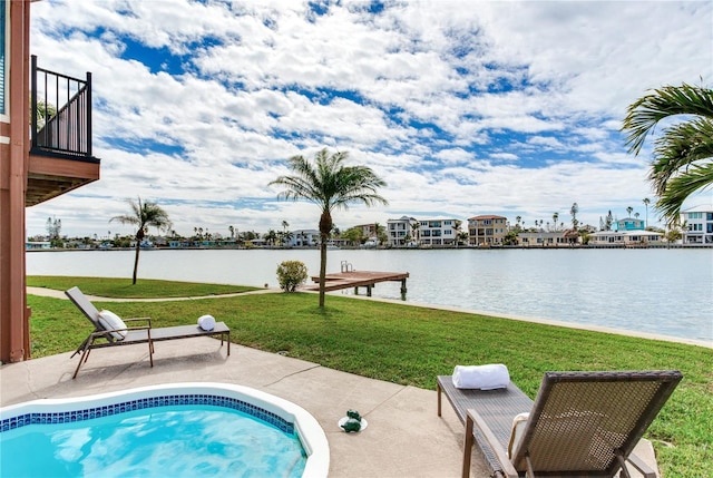 view of pool featuring a yard, a water view, and a patio area