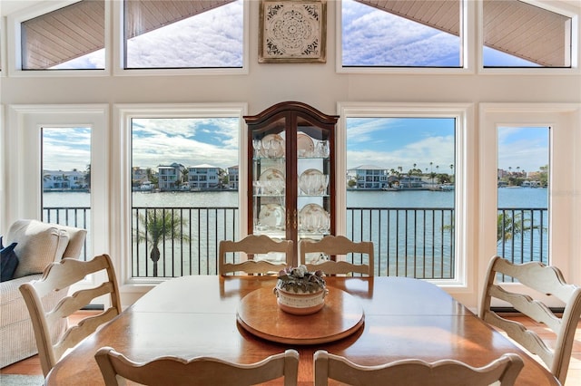 dining space featuring a water view, a wealth of natural light, and lofted ceiling