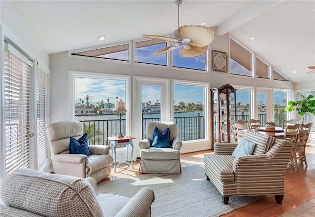 sunroom featuring ceiling fan, vaulted ceiling with beams, and a water view