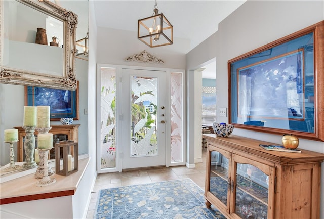 tiled foyer entrance featuring plenty of natural light and a chandelier