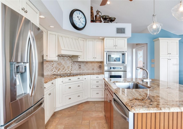 kitchen with sink, white cabinetry, stainless steel appliances, and an island with sink