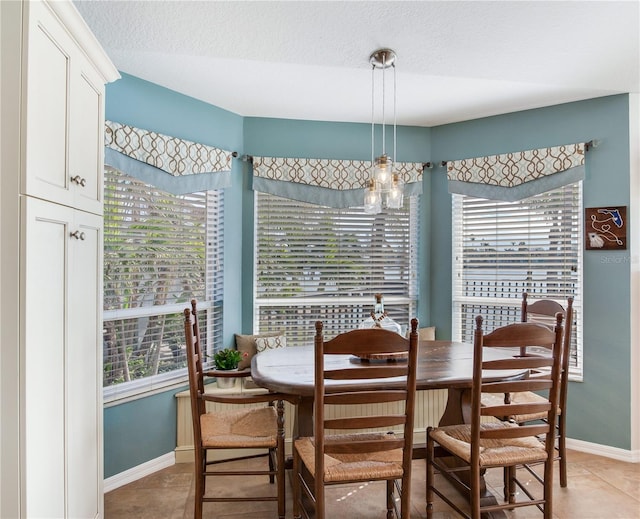 tiled dining space featuring a textured ceiling