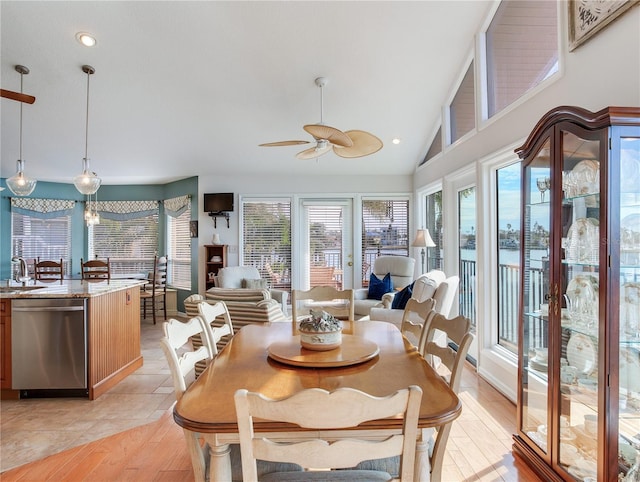 dining space featuring ceiling fan, light tile patterned floors, vaulted ceiling, and a wealth of natural light