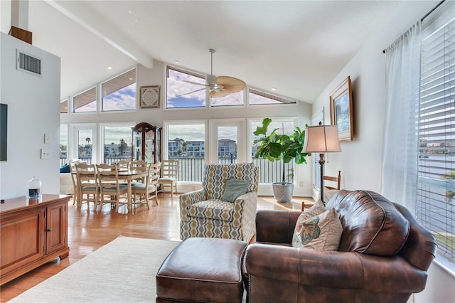 living room featuring ceiling fan, beamed ceiling, and high vaulted ceiling