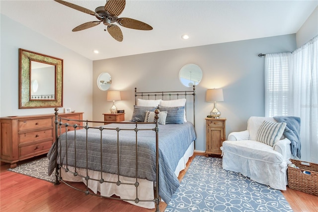 bedroom with ceiling fan, multiple windows, wood-type flooring, and lofted ceiling