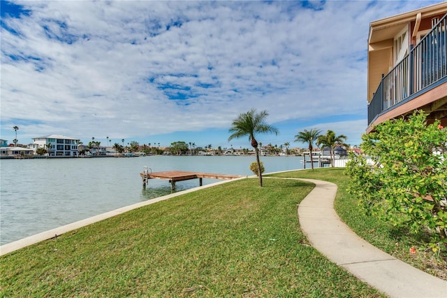 exterior space with a boat dock, a yard, and a water view