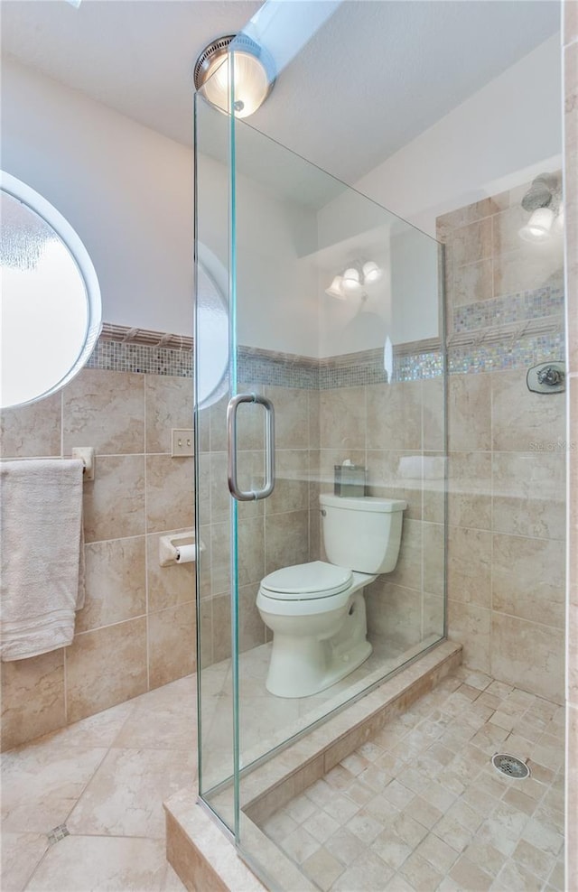 bathroom with toilet, tile walls, and walk in shower