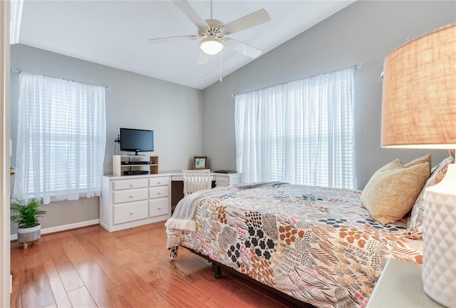 bedroom with multiple windows, ceiling fan, vaulted ceiling, and light hardwood / wood-style floors