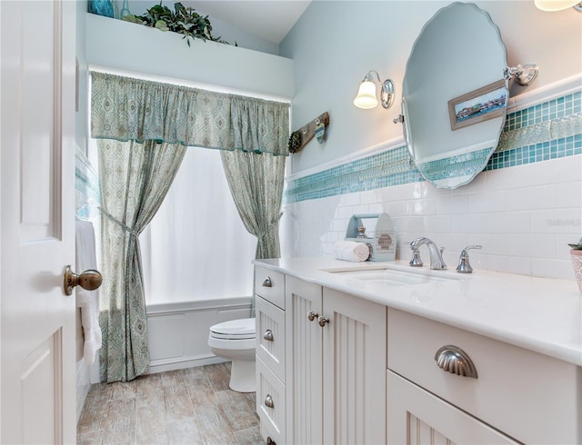 full bathroom with vanity, tile walls, toilet, and shower / tub combo