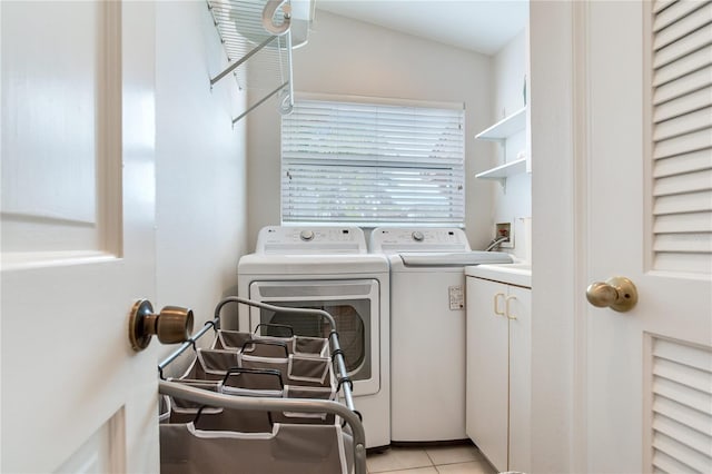 laundry room featuring light tile patterned flooring, washer and dryer, and cabinets