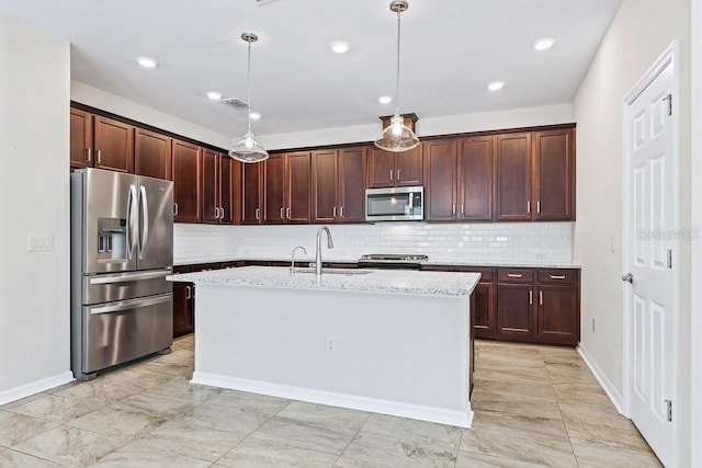 kitchen featuring light stone counters, pendant lighting, stainless steel appliances, a center island with sink, and sink