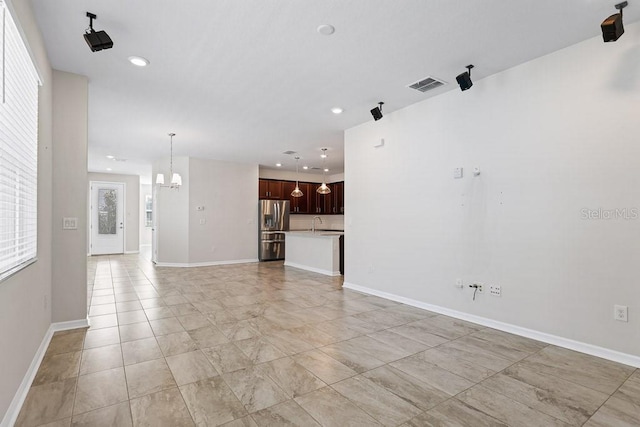 unfurnished living room featuring a notable chandelier