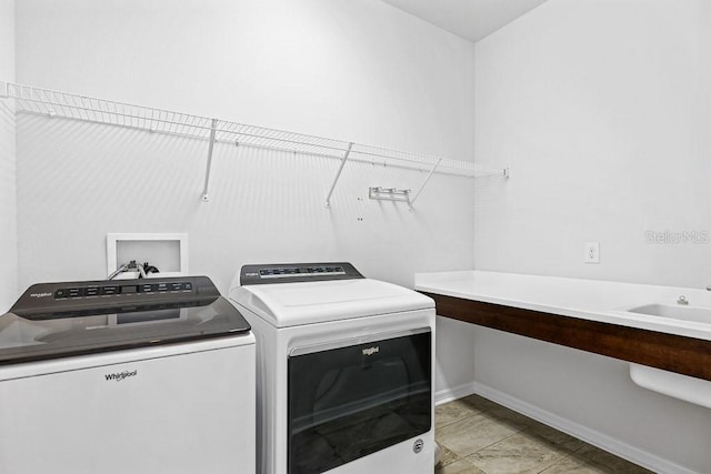 laundry room with independent washer and dryer, light tile patterned floors, and sink