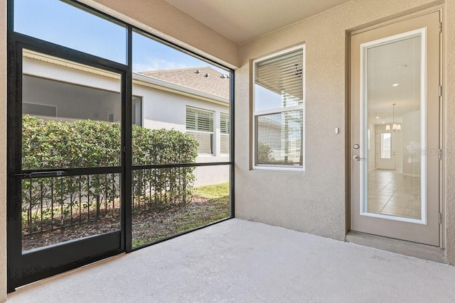 unfurnished sunroom with a notable chandelier