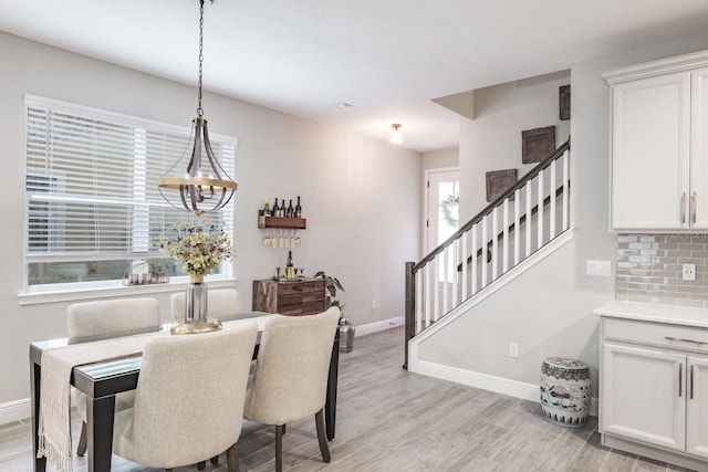 dining area with a notable chandelier and light hardwood / wood-style floors