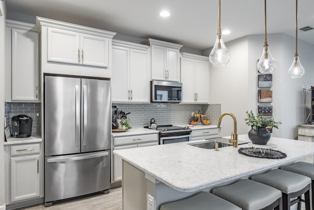 kitchen featuring white cabinets, stainless steel appliances, sink, and pendant lighting