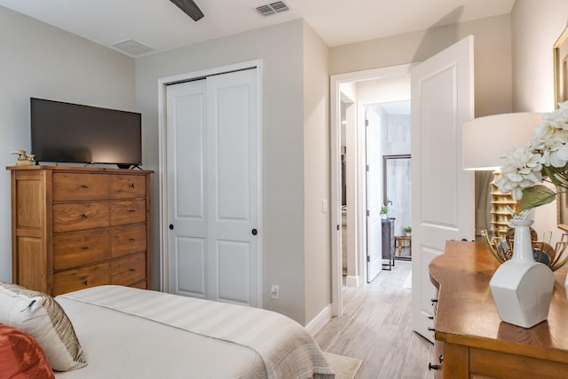 bedroom with ceiling fan, light hardwood / wood-style flooring, and a closet