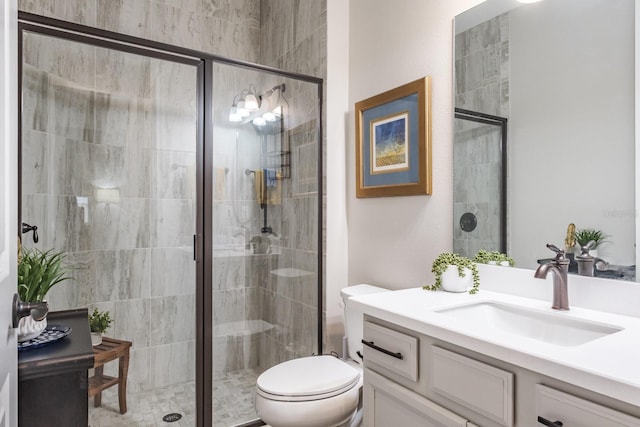 bathroom with an enclosed shower, vanity, and toilet