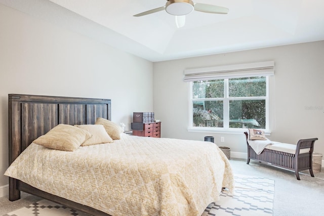 bedroom featuring ceiling fan, light carpet, and a tray ceiling