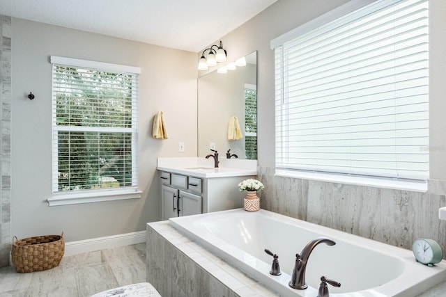 bathroom featuring vanity and a relaxing tiled tub