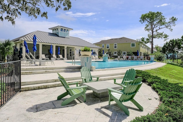 view of swimming pool featuring pool water feature and a patio