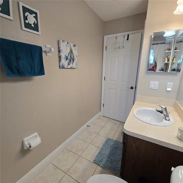 bathroom with tile patterned flooring, vanity, and toilet