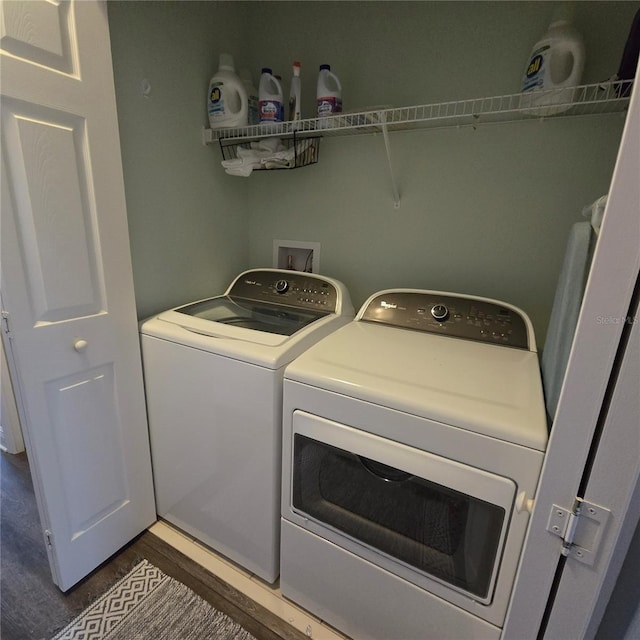 laundry room with washer and clothes dryer and dark hardwood / wood-style floors