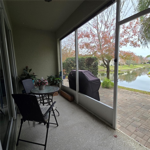 sunroom featuring a water view