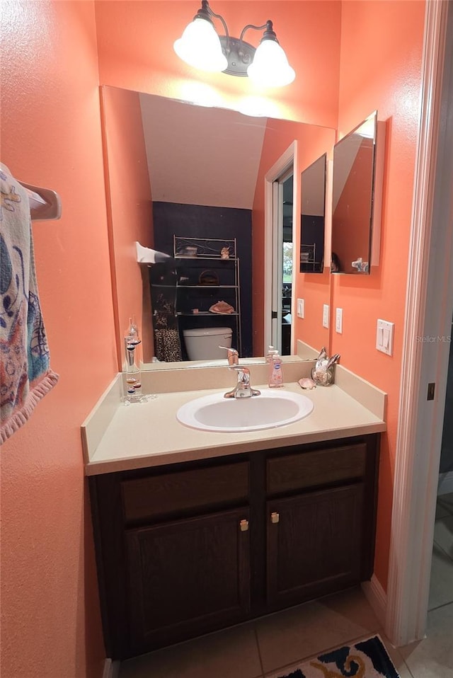 bathroom with tile patterned flooring, vanity, and toilet