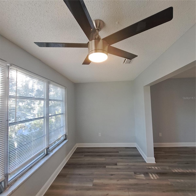 unfurnished room featuring dark wood-type flooring, a textured ceiling, and ceiling fan