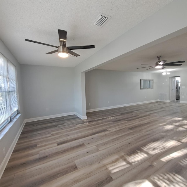 empty room with a textured ceiling and hardwood / wood-style floors