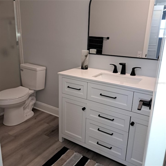 bathroom featuring toilet, an enclosed shower, wood-type flooring, and vanity