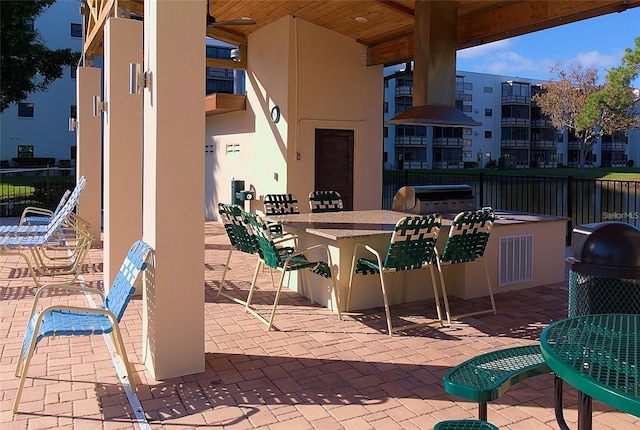 view of patio / terrace with exterior bar, ceiling fan, and area for grilling