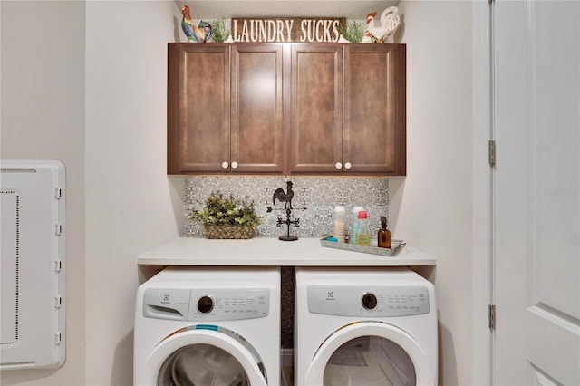 washroom with washer and dryer and cabinets