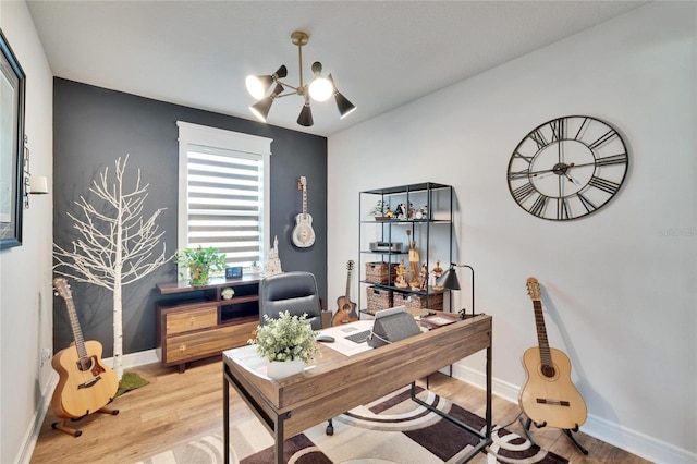 home office with wood-type flooring and an inviting chandelier