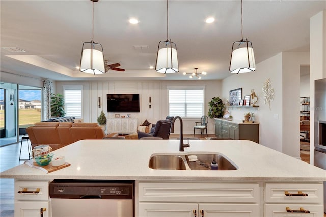 kitchen with white cabinetry, dishwasher, sink, a raised ceiling, and pendant lighting