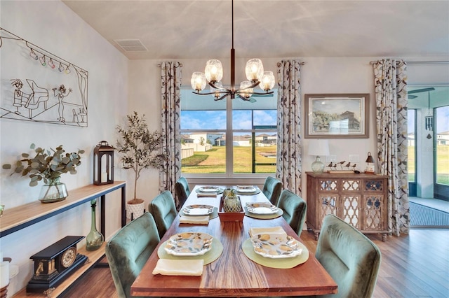 dining area featuring hardwood / wood-style floors and a notable chandelier