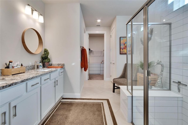 bathroom with tile patterned flooring, vanity, and walk in shower