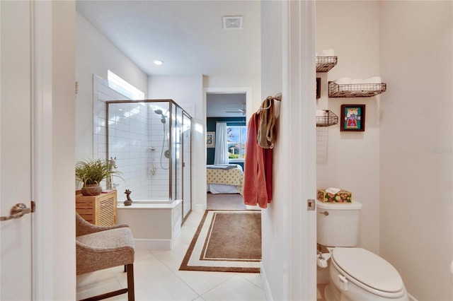 bathroom with tile patterned floors, toilet, and a shower with door