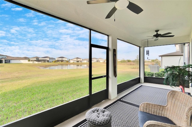 sunroom with a water view and ceiling fan