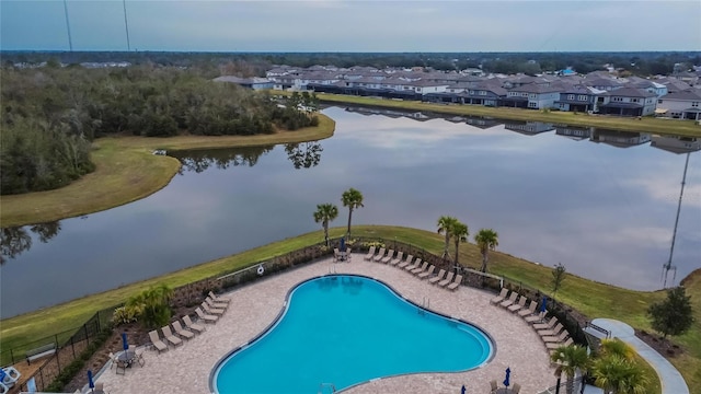 view of swimming pool featuring a patio and a water view