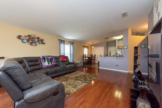 living room featuring dark wood-type flooring and vaulted ceiling