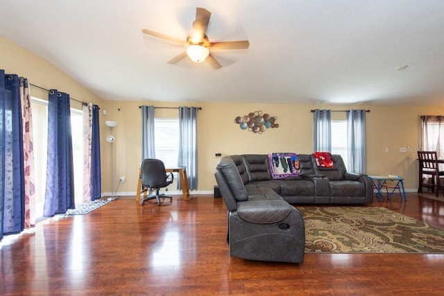 living room with ceiling fan and dark wood-type flooring