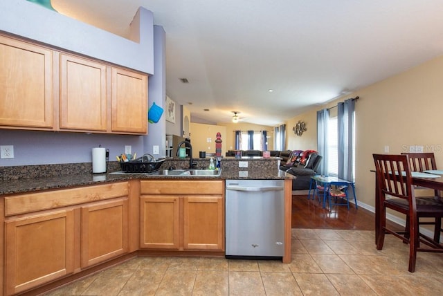 kitchen with dishwasher, dark stone counters, sink, vaulted ceiling, and kitchen peninsula