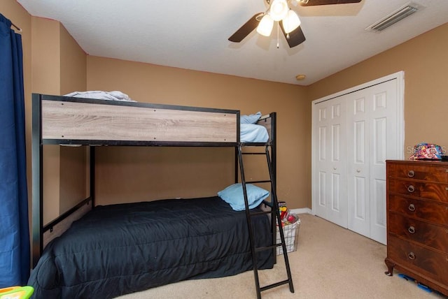 carpeted bedroom featuring a closet and ceiling fan