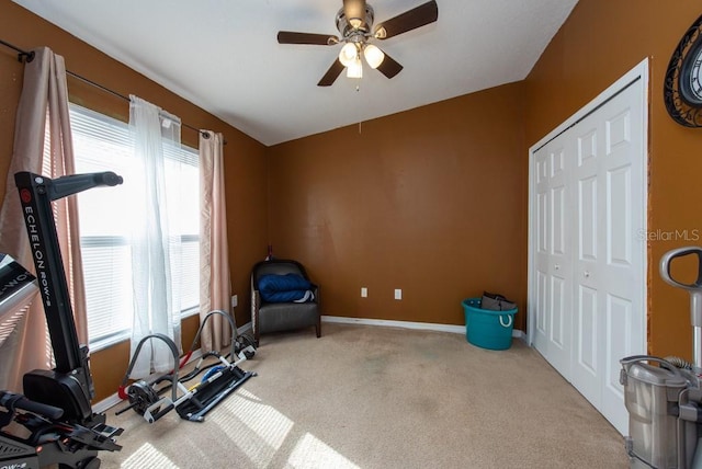 workout area with ceiling fan and light colored carpet